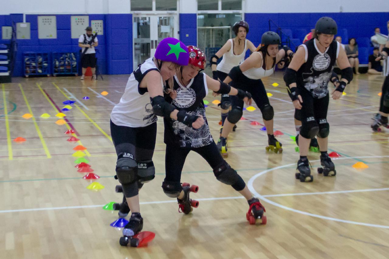 The closing scrimmage, blocker engaging jammer at the outside-edge of the track.