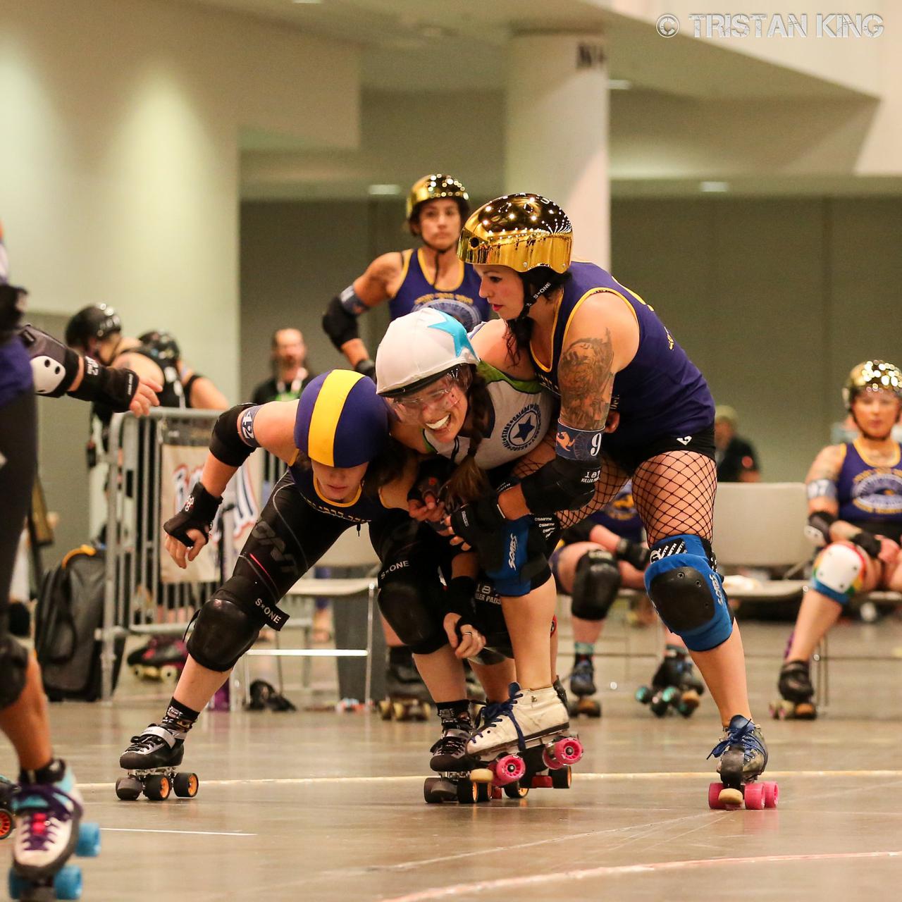 Team Indigenous and Jewish Roller Derby skaters in a complex blocking situation