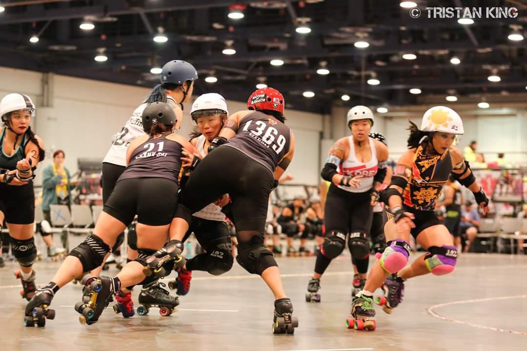 Action from the Korea / Philippines game, Philippines jammer on inside line passing blocked Korea jammer in pack.